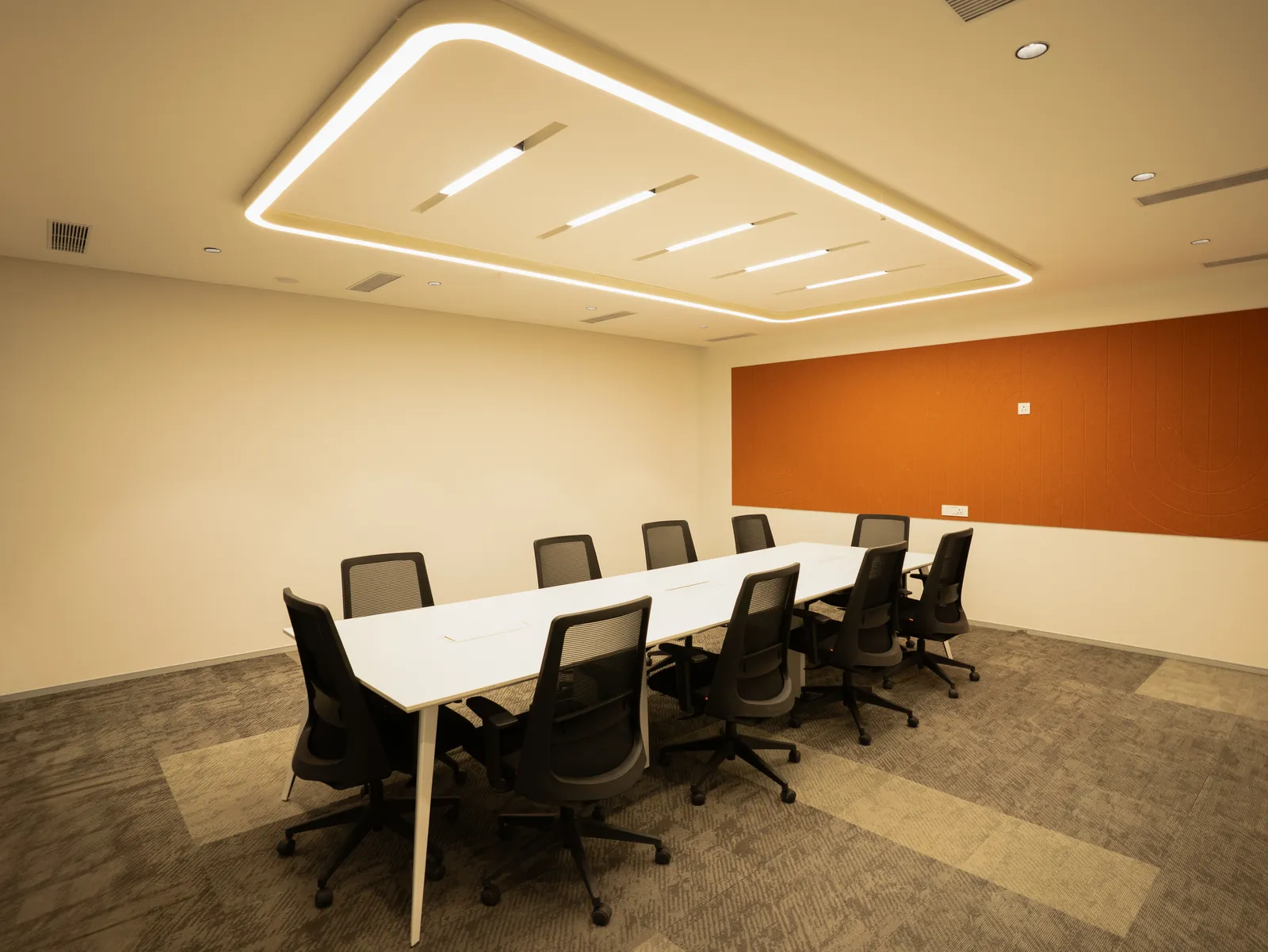 Conference room with cove-lit ceiling and orange wall panel — Moschip